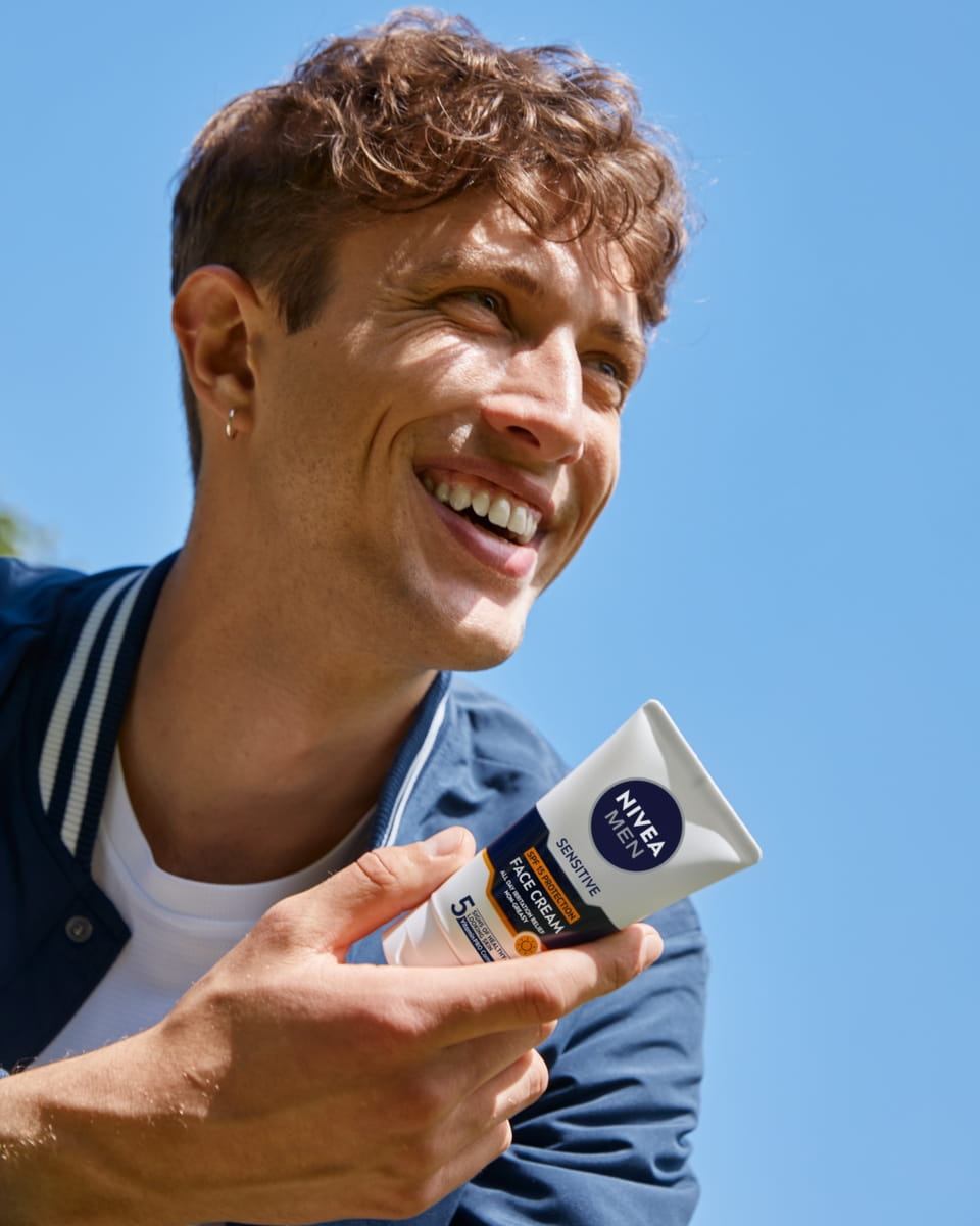 Young man using Nivea SPF face cream