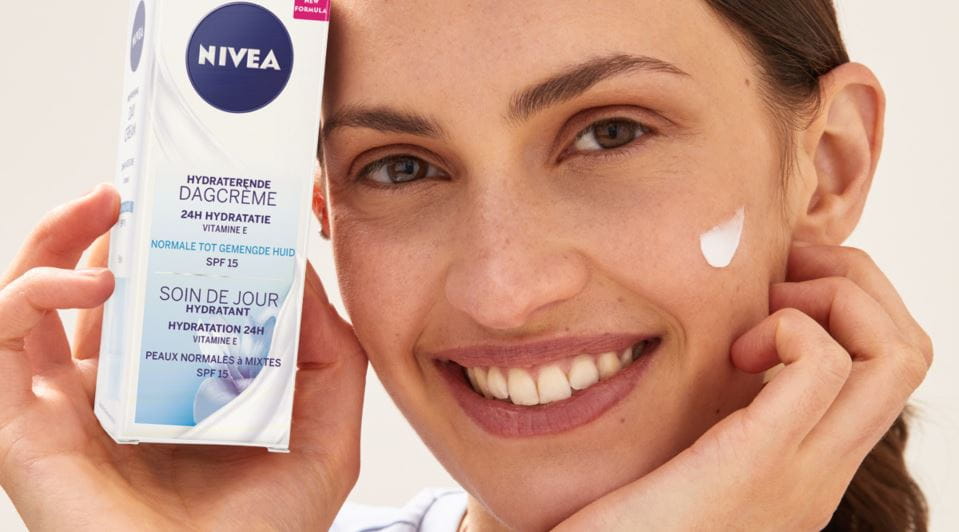 Vrouw blaast op vinger met crĆØme erop