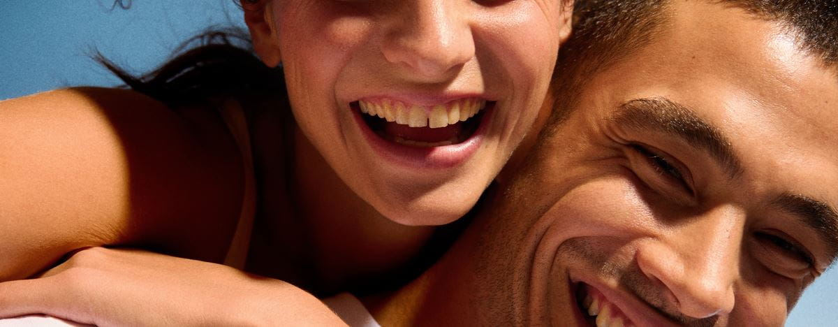Homme embrasse joue d'une femme souriante