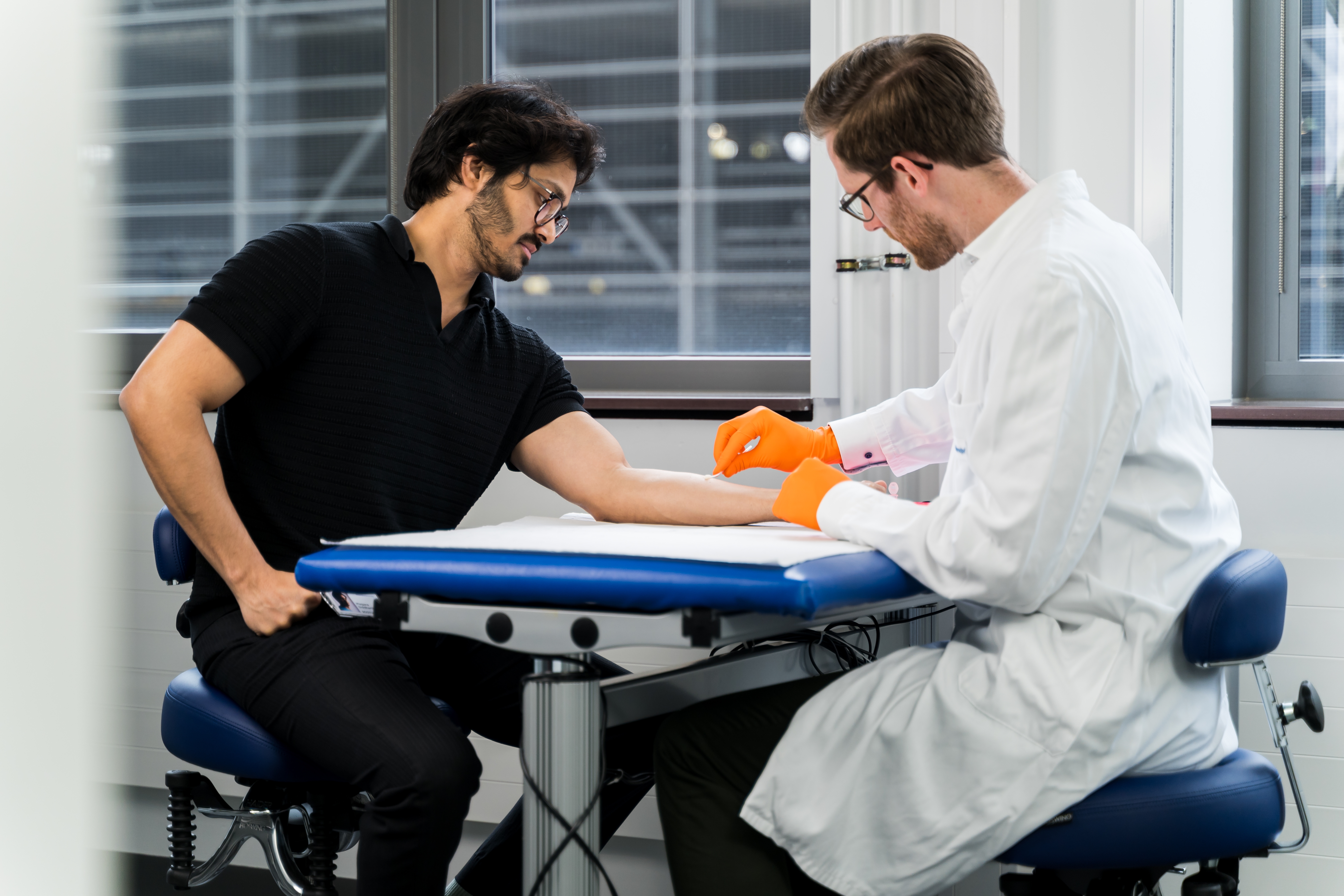 Two people with facial masks and towels on their heads smiling.