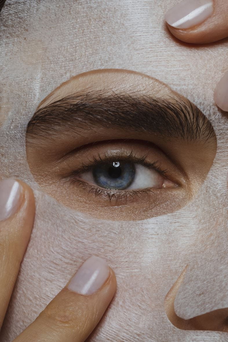 vrouw die een masker op haar gezicht aanbrengt