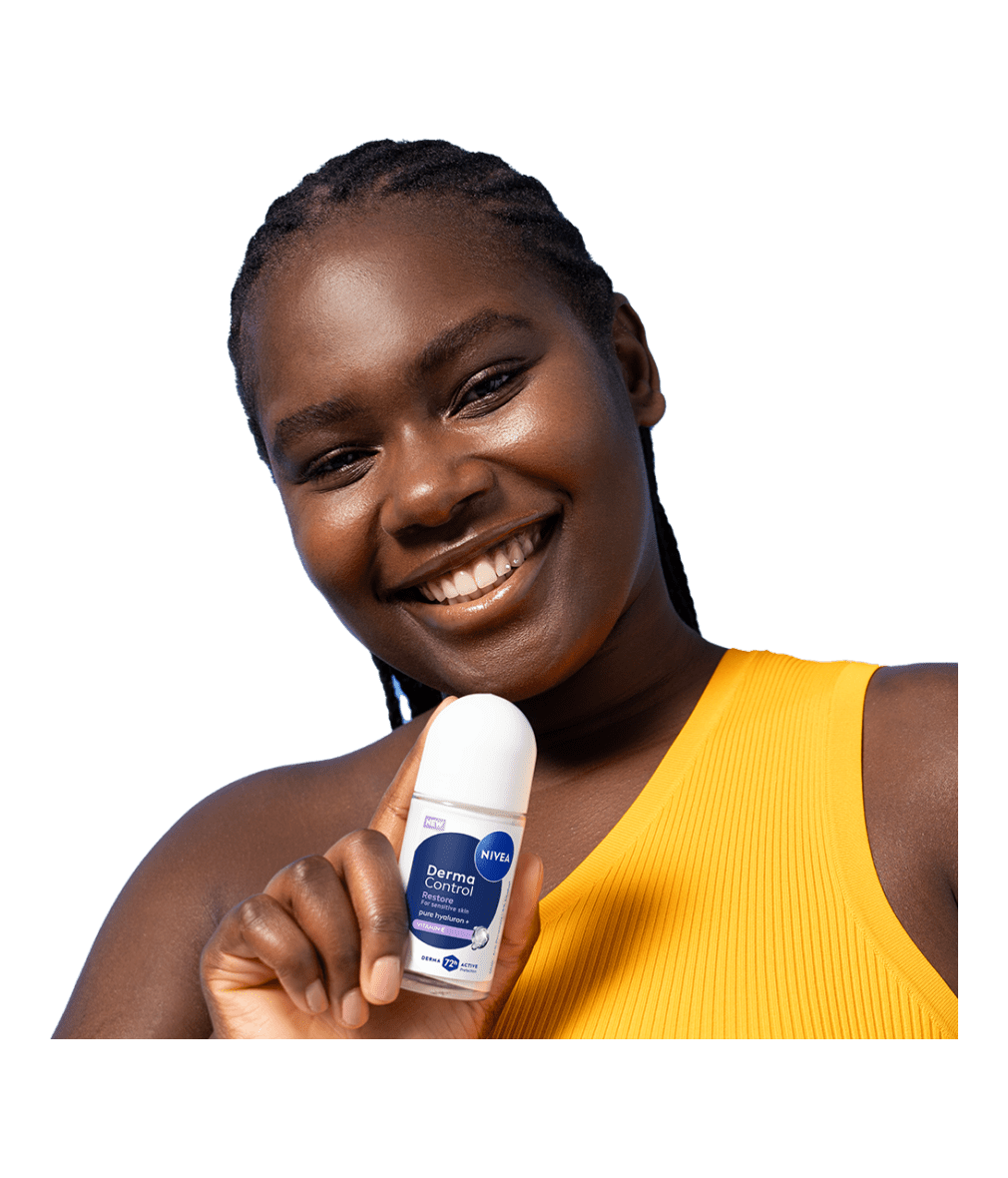 A young smiling woman tilts her head while holding up NIVEA Derma Control Restore Deo Roll-On.