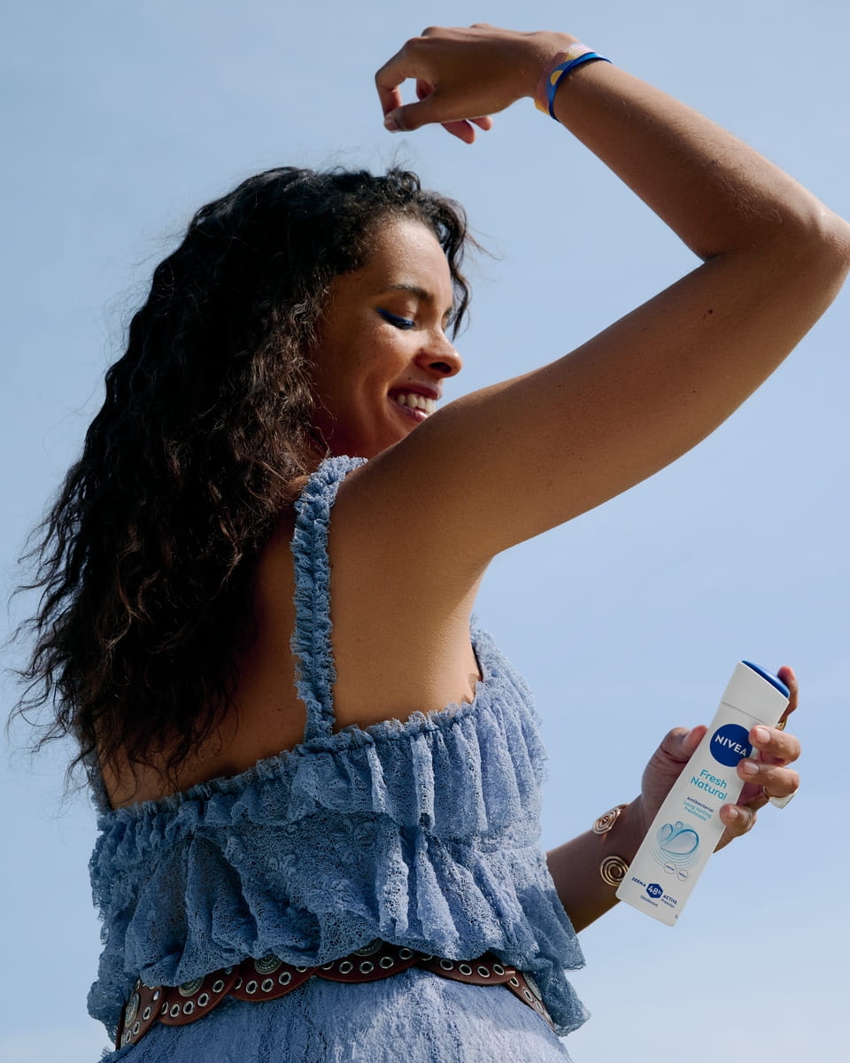 Młoda kobieta używająca dezodorantu Nivea Fresh Natural