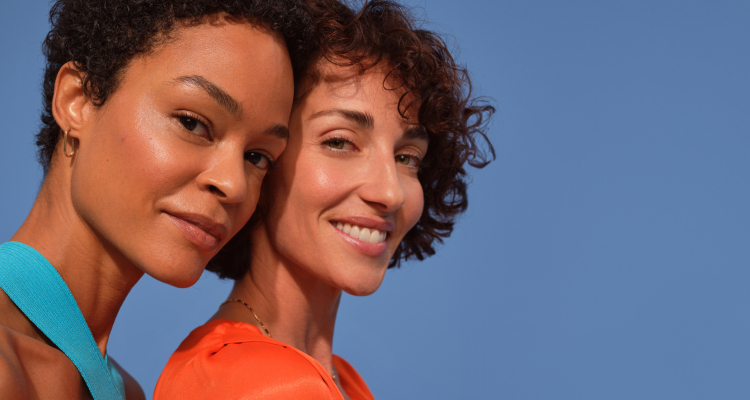 Žena se zrzavými vlasy drží krém na obličej Nivea Q10