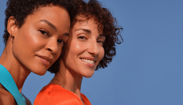 Žena se zrzavými vlasy drží krém na obličej Nivea Q10