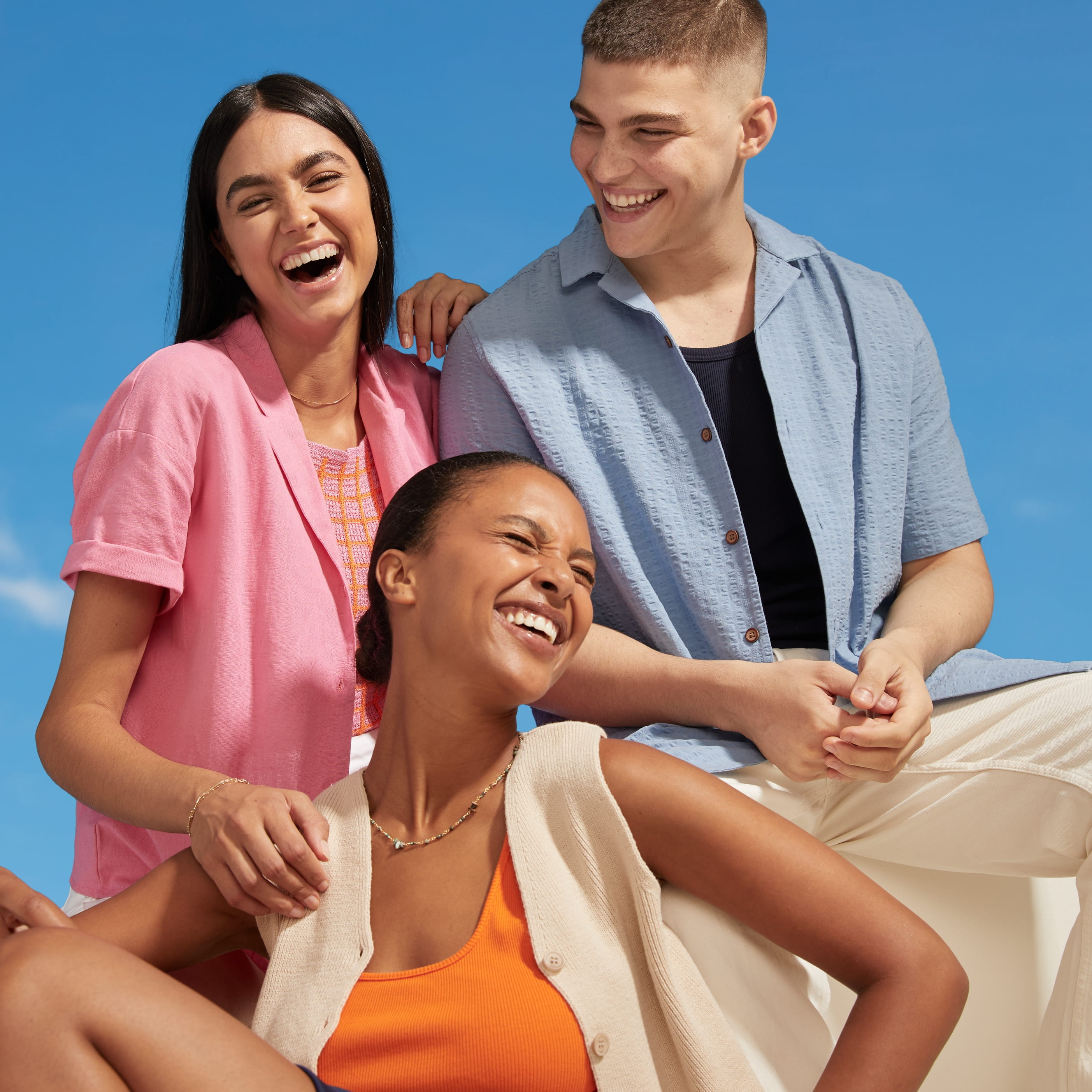 Tre personer som sitter i grupp och ler