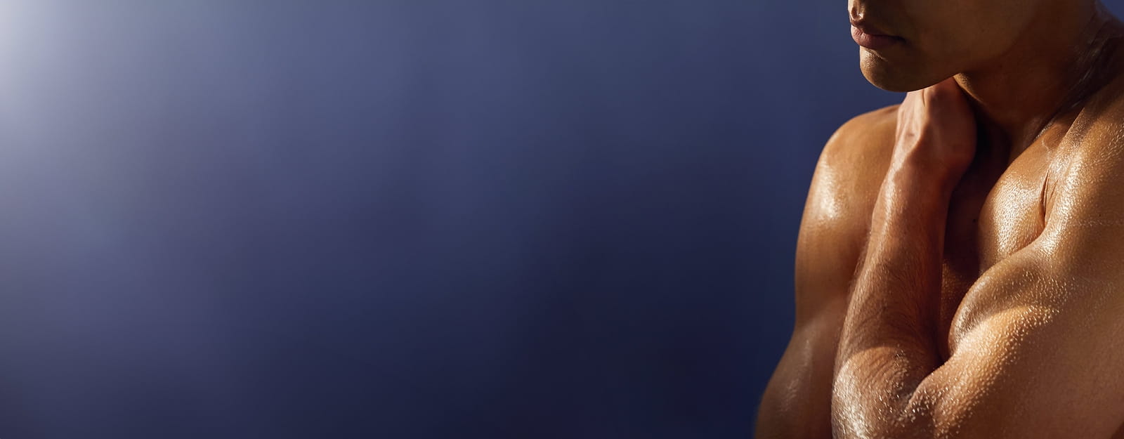 A shirtless person seen against a dark blue gradient background.