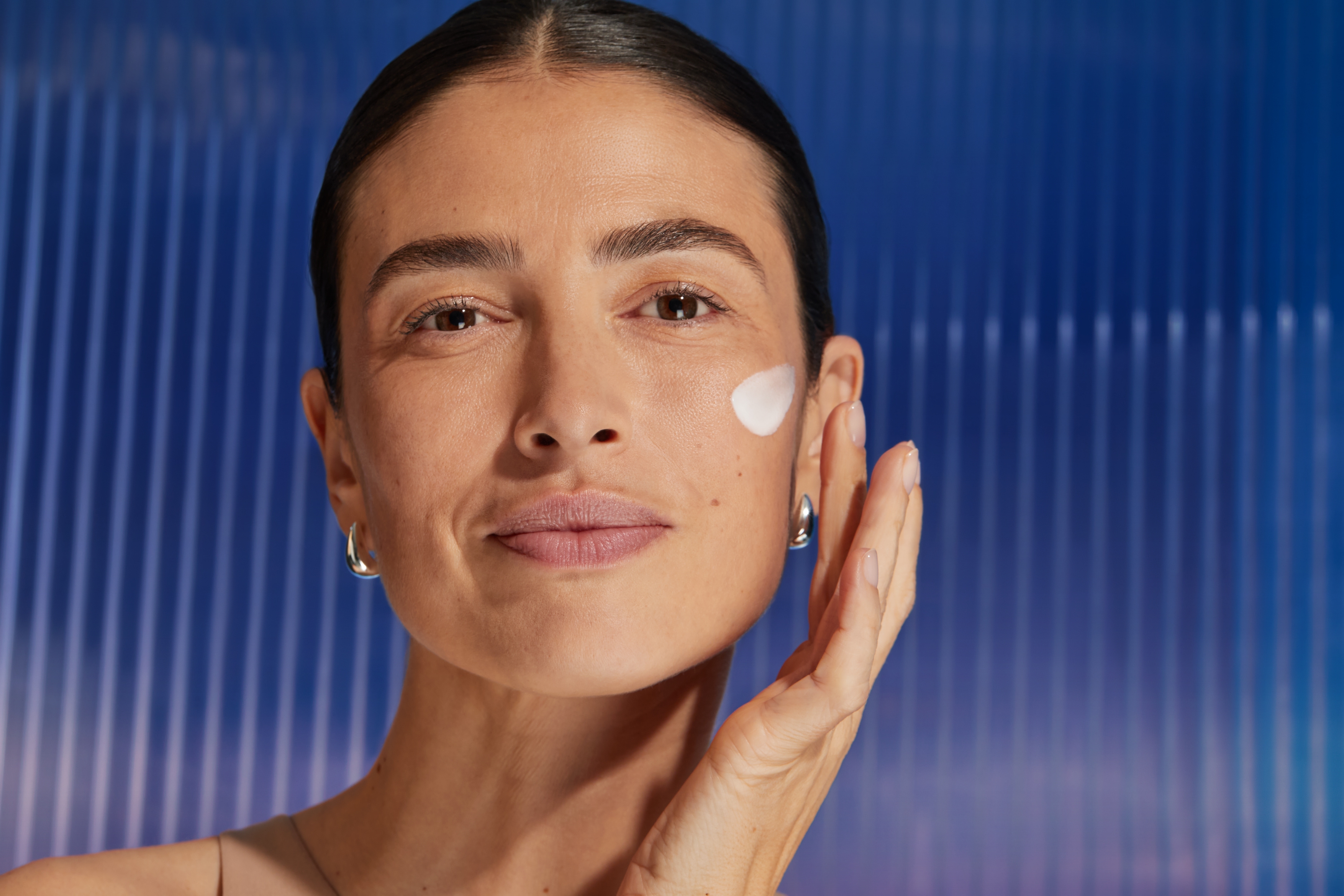 Kvinna applicerar serum på kinden