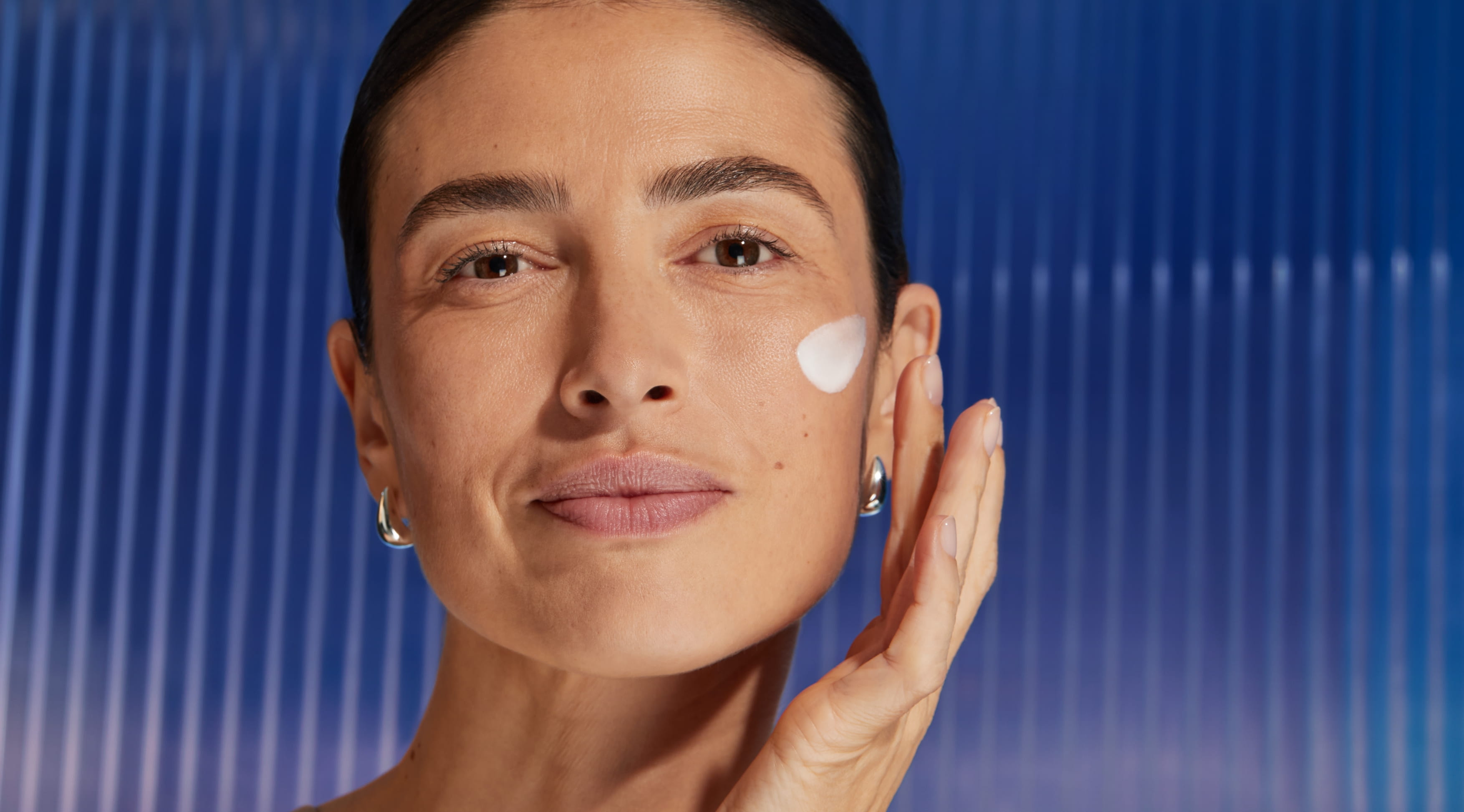 Kvinna applicerar serum på kinden