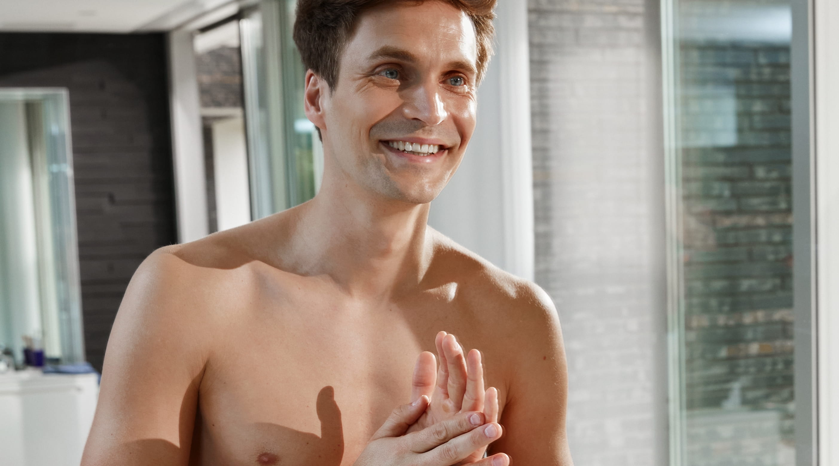 Man tittar sig själv i spegeln och ler