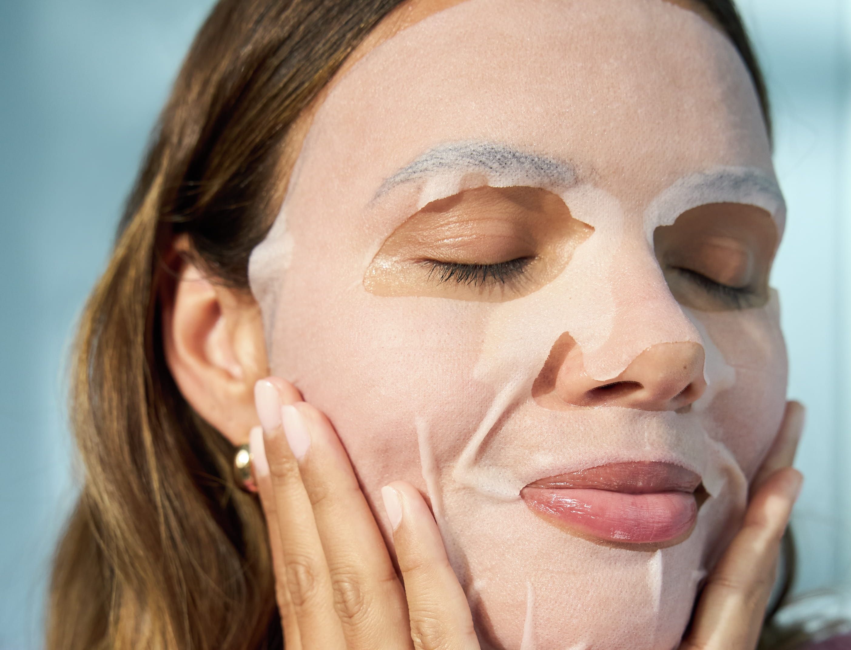 tjej som blundar och njuter av sin ansiktsmask