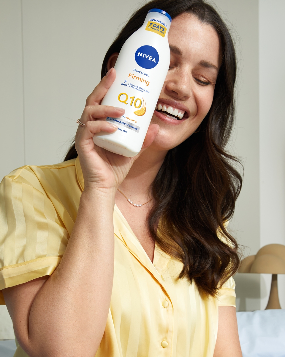 Young woman using Nivea Firming Q10 Body Lotion