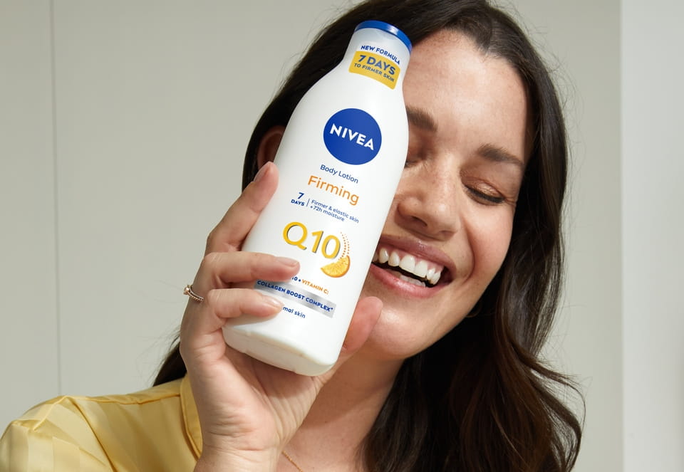Young woman using Nivea Firming Q10 Body Lotion