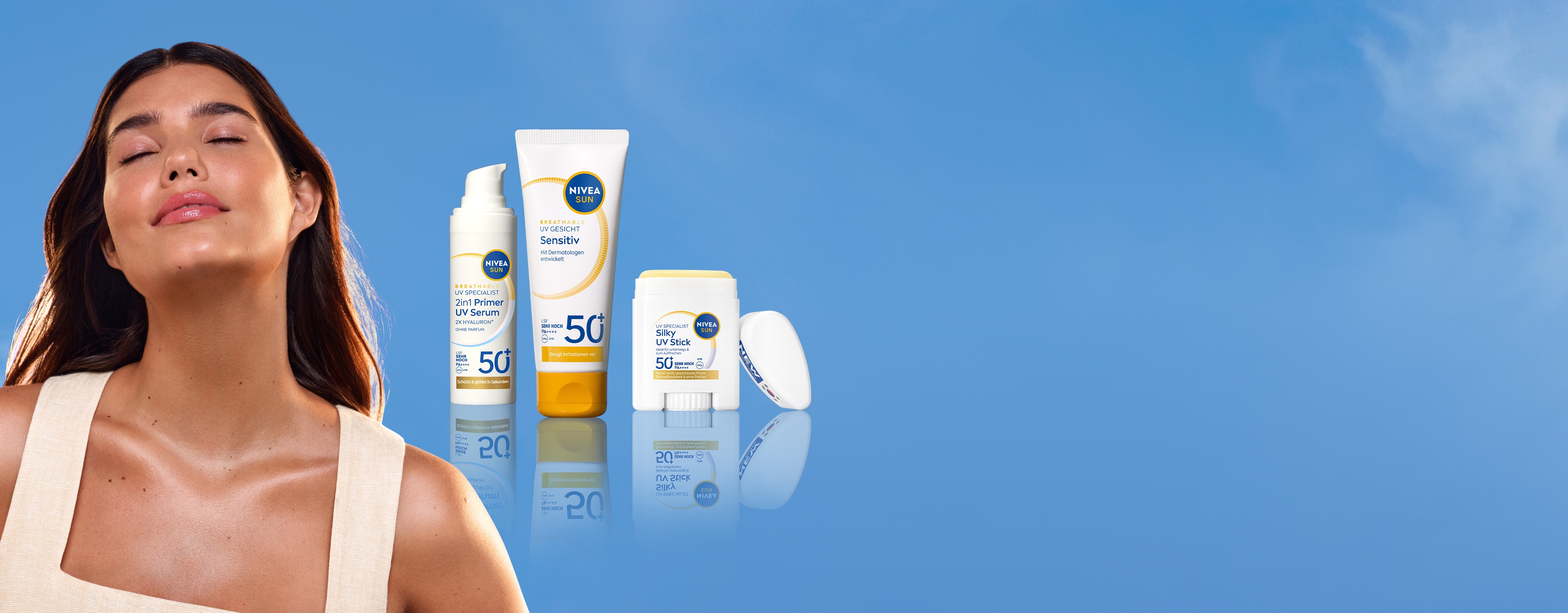 Eine junge Frau mit geschlossenen Augen, geneigtem Kopf, lächelnd, zurückgelehnt, sich sonnend mit strahlender Haut, in der Nähe von NIVEA SUN-Produkten.