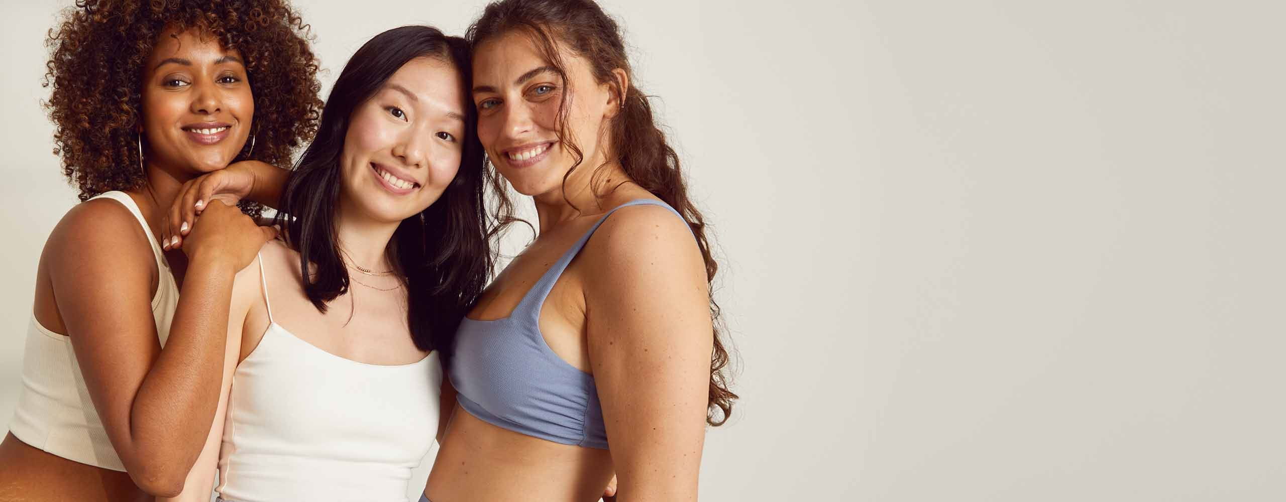 rois personnes se tiennent près les unes des autres en se souriant et en s'embrassant.