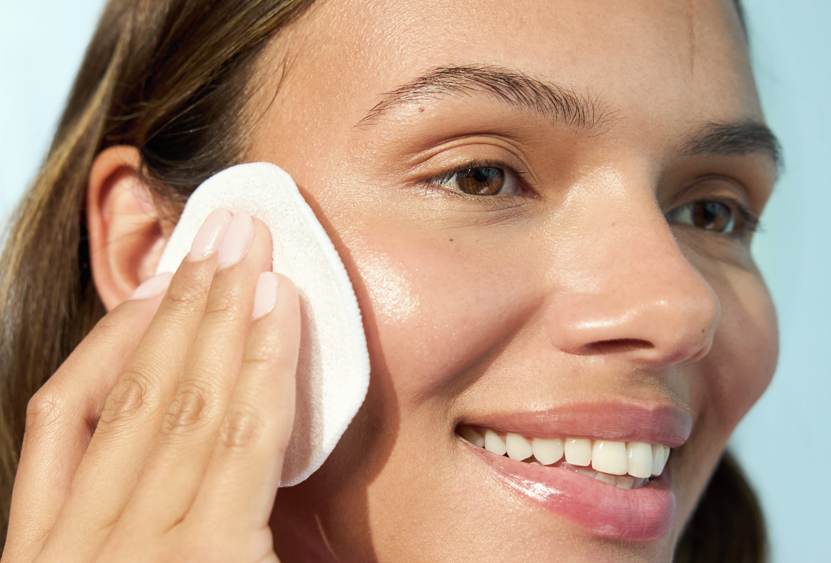 Kvinna som tar bort smink med bomullspad