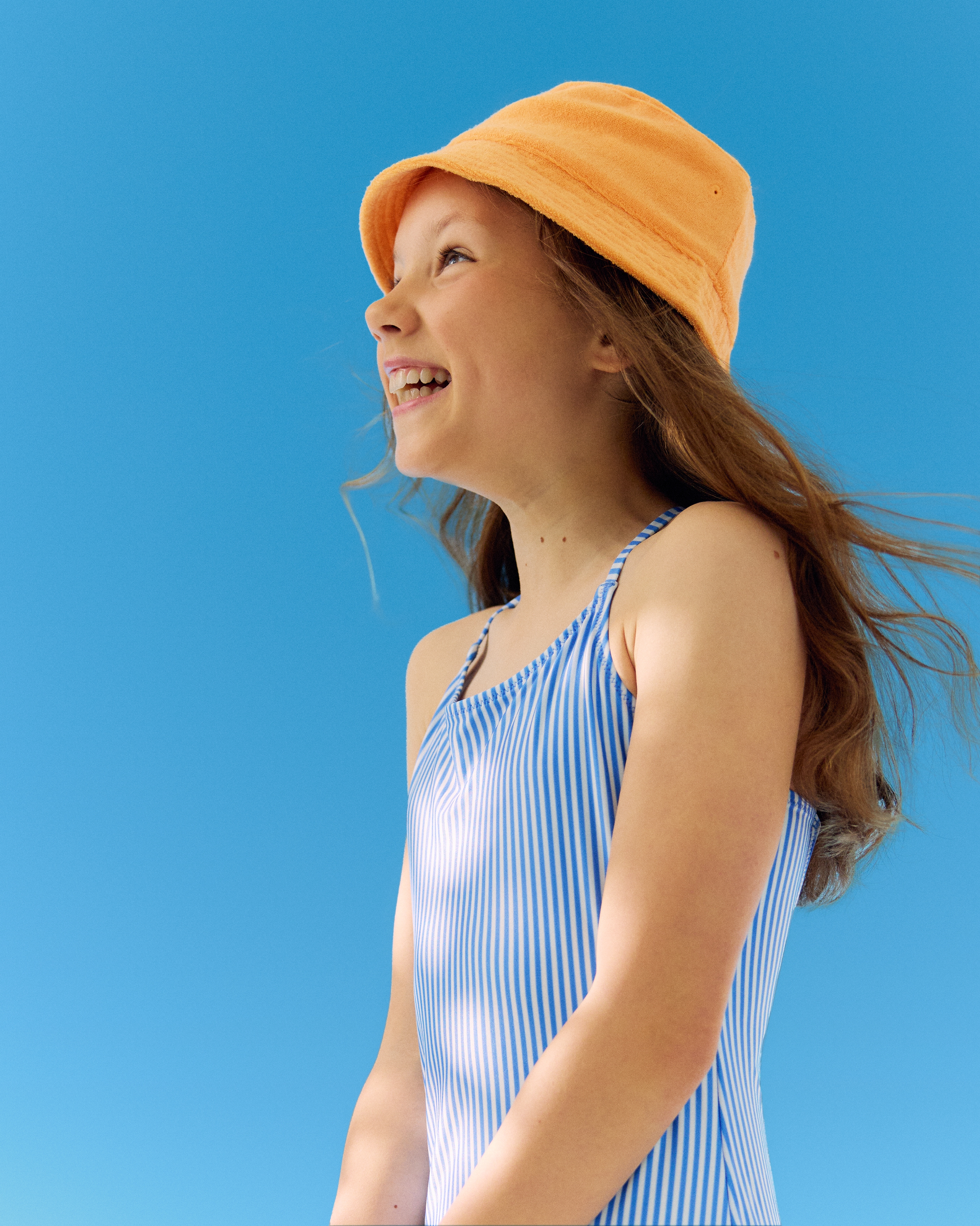 liten flicka som använder Nivea solkräm roll-on