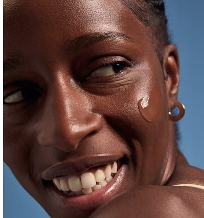 A woman with Every Tone clear sunscreen on her face