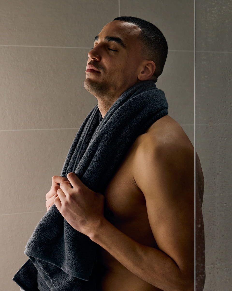 Young man with towel getting ready to shower
