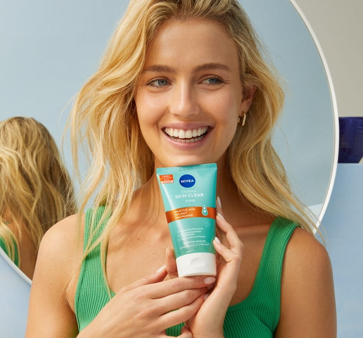 Young woman using NIVEA Derma Skin Clear Scrub