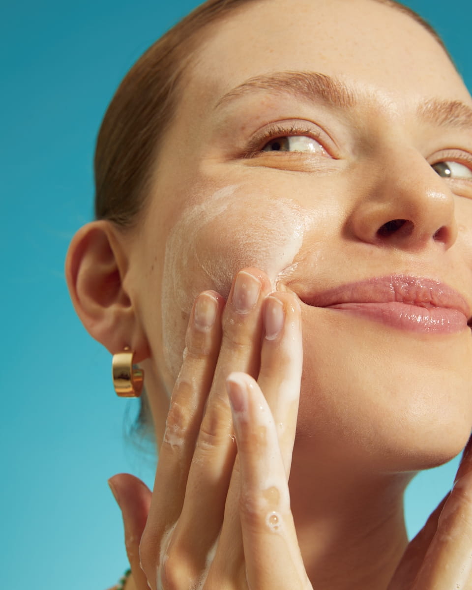 Jonge vrouw die haar gezicht wast