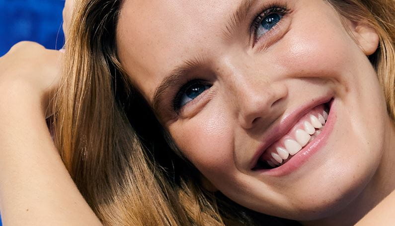 Gyömbéres hajú nő a kezében egy Nivea Q10 arckrémmel