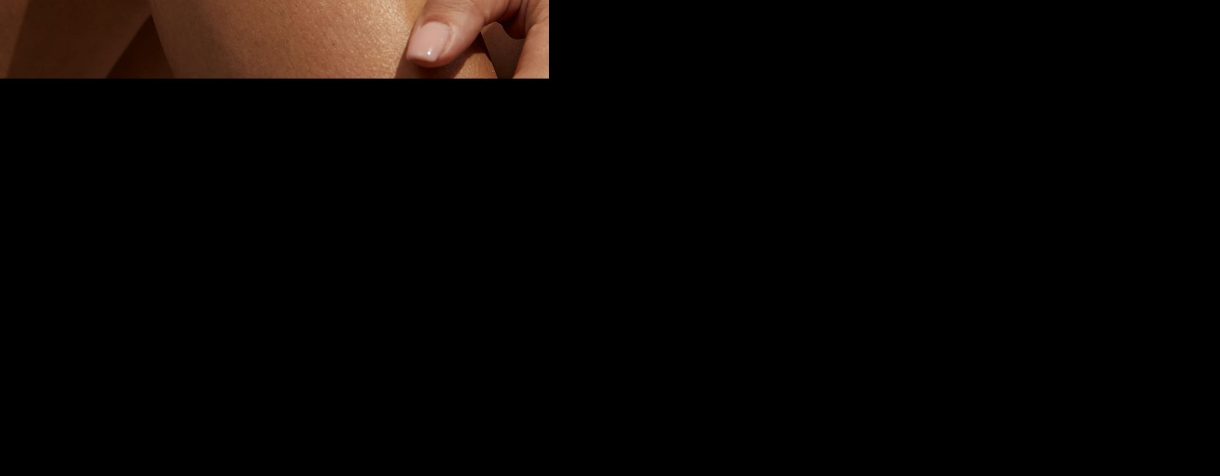 Frau liegt auf dem Gras und lächelt