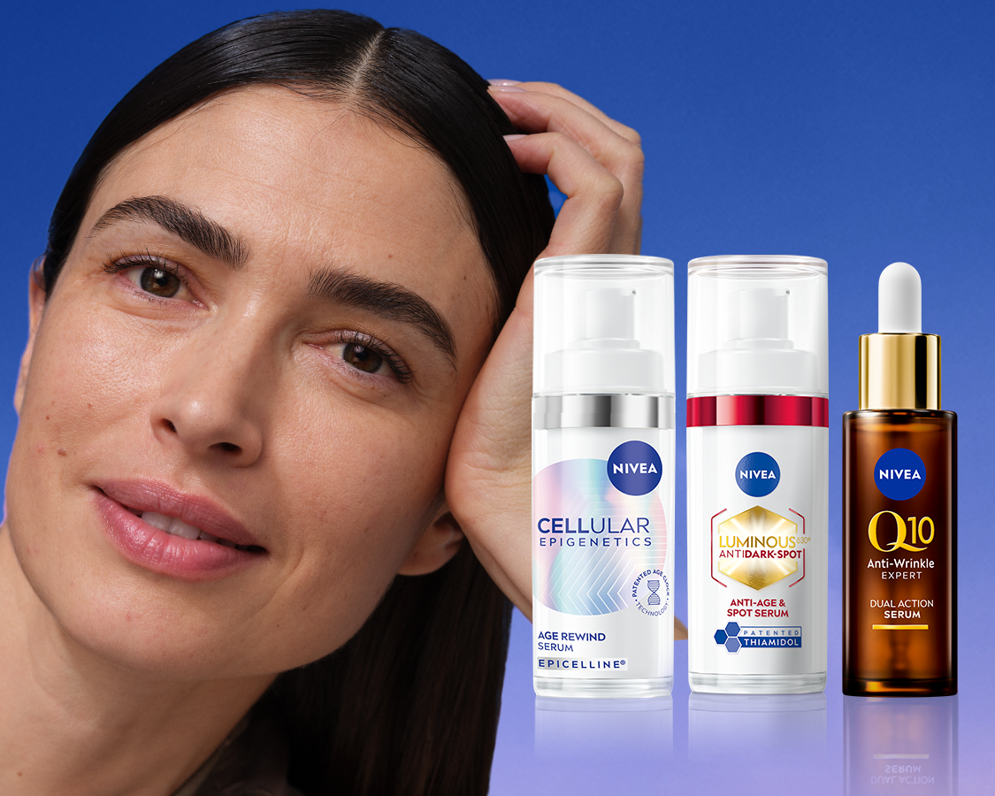 Nainen nojaa päätään tukevaan käteensä, vieressä kolme NIVEAn anti-age-tuotetta.