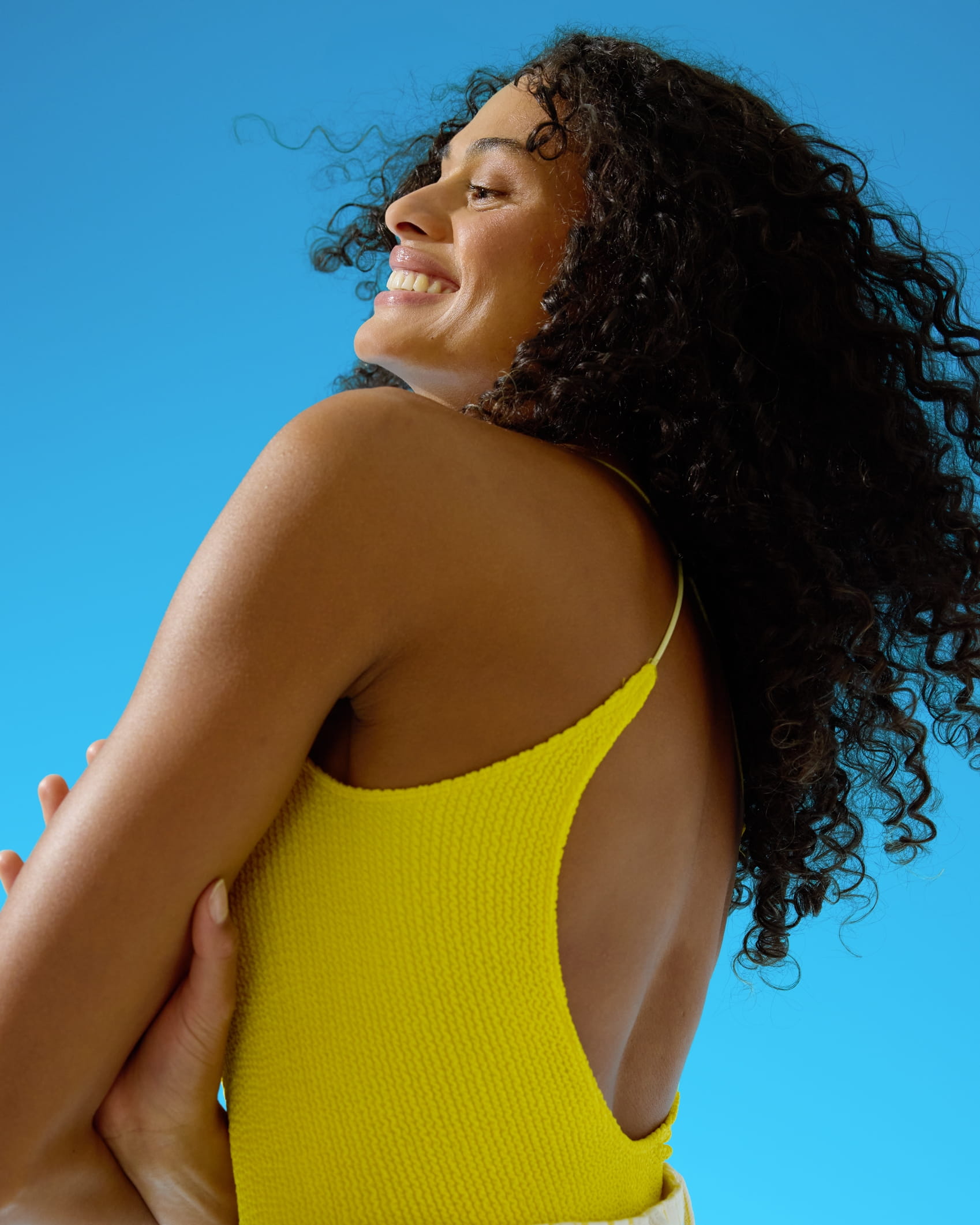 Donna di capelli ricci allo zenzero che tiene una crema per il viso Nivea