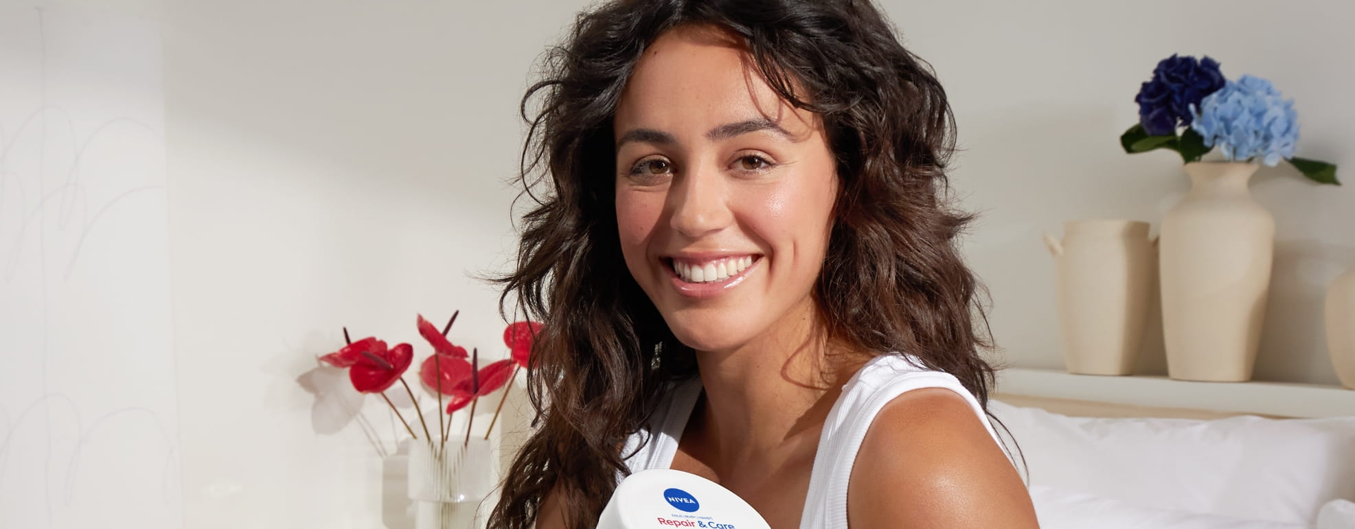 Mujer joven usando la crema Nivea Repair & Care