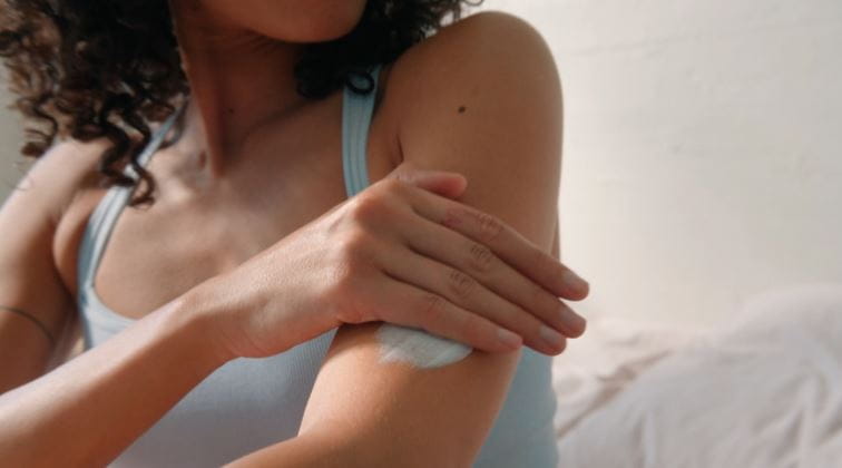 mujer echándose crema