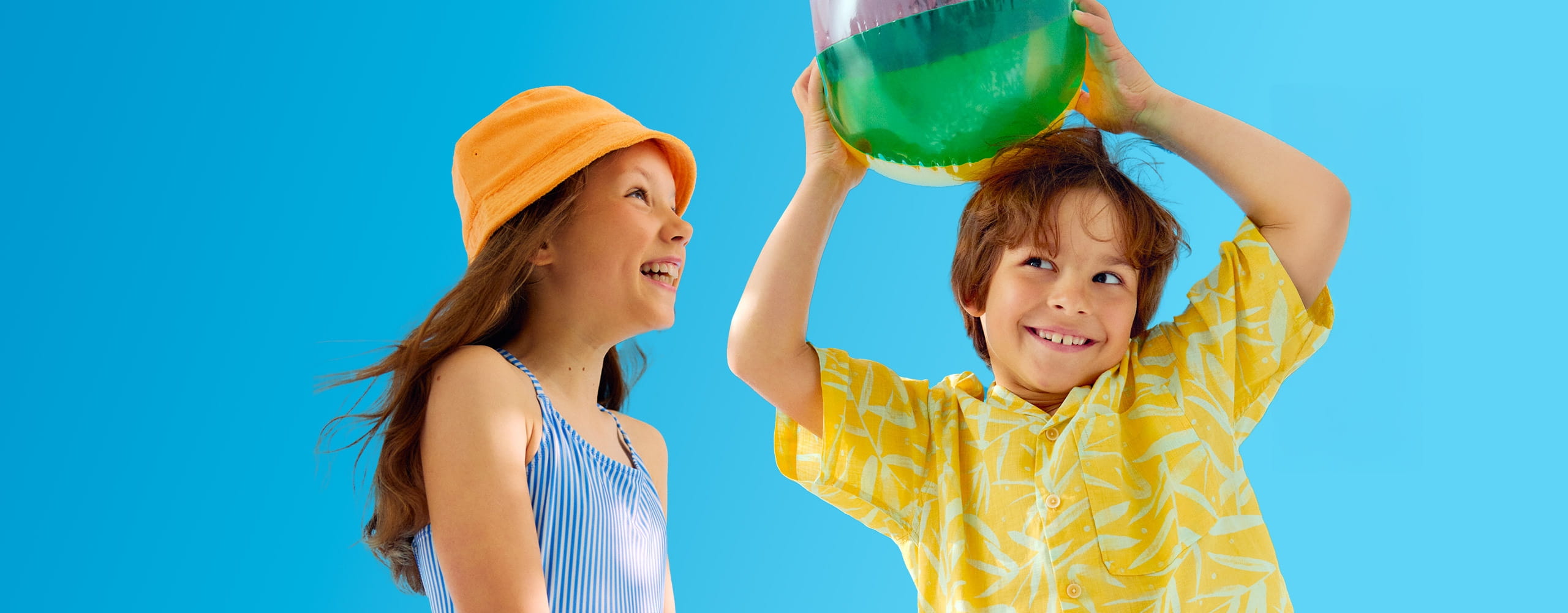 Un bambino e una bambina che giocano con un pallone da spiaggia