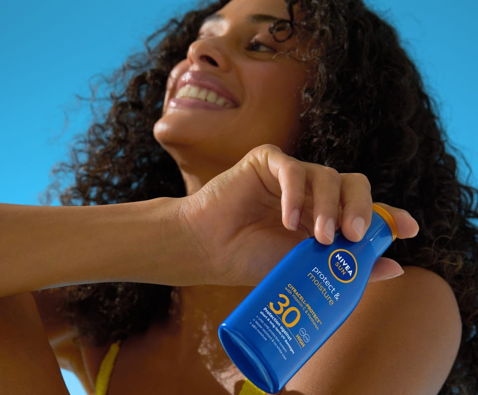 jonge vrouw gebruikt NIVEA Protection And Moisture Lotion SPF 30