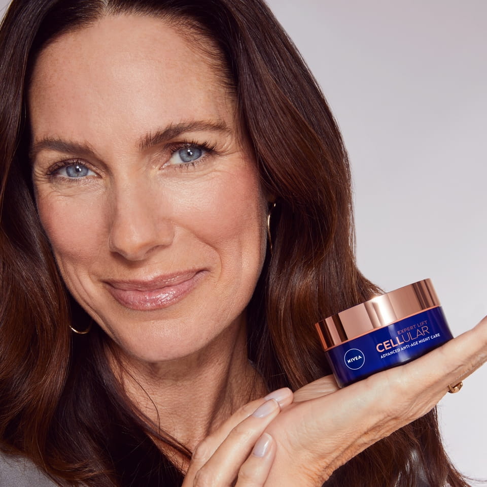 Nivea Cellular Expert Lift -kasvovoiteen käyttävä nainen