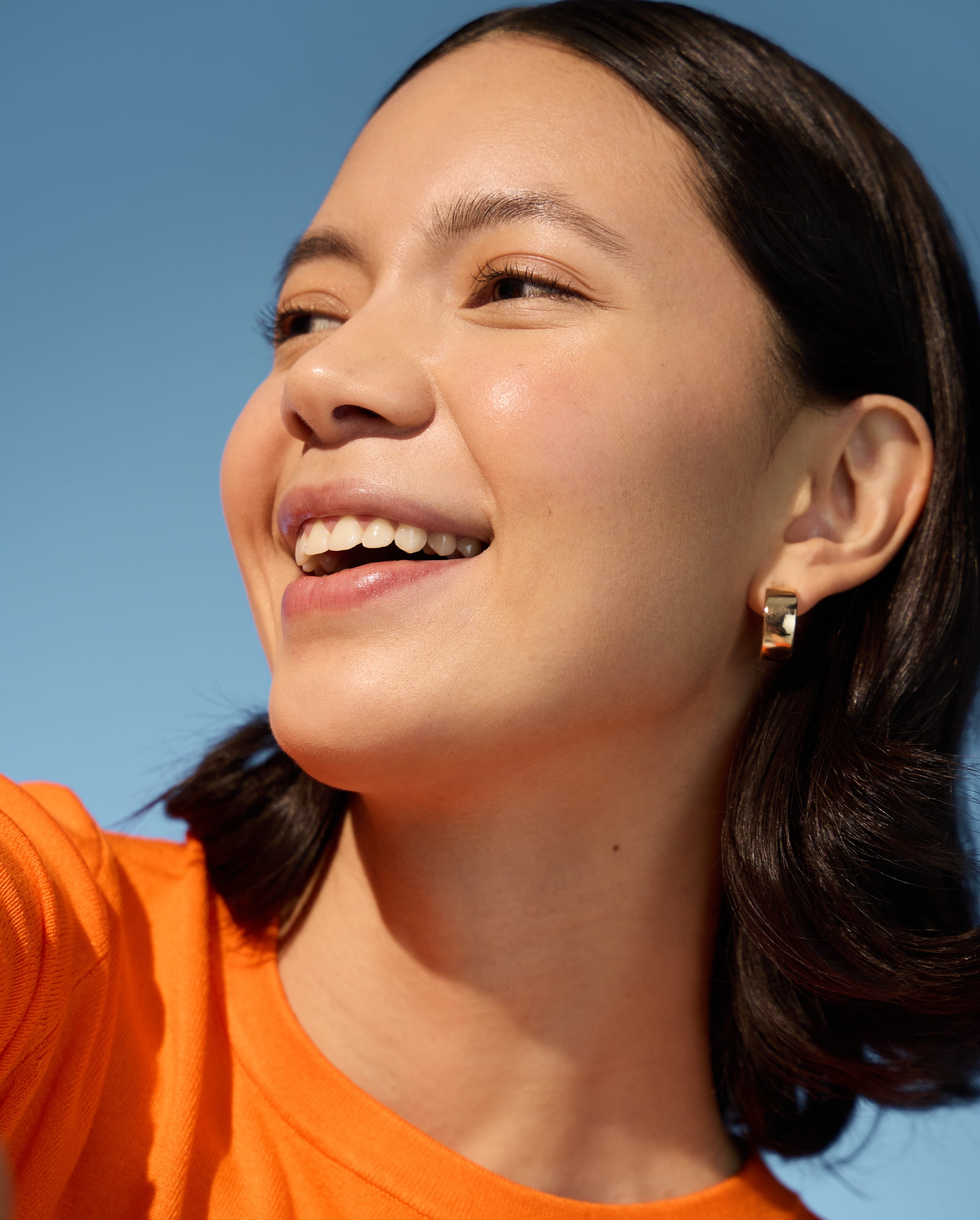 person tittar över hennes vänstra axel och ler