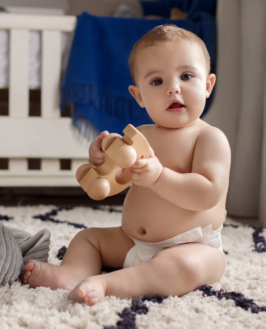 Ein Baby, das sitzt und mit Spielzeug spielt