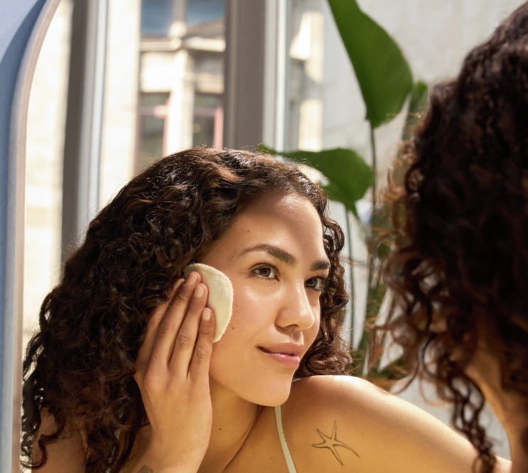 Jonge vrouw die haar gezicht reinigt