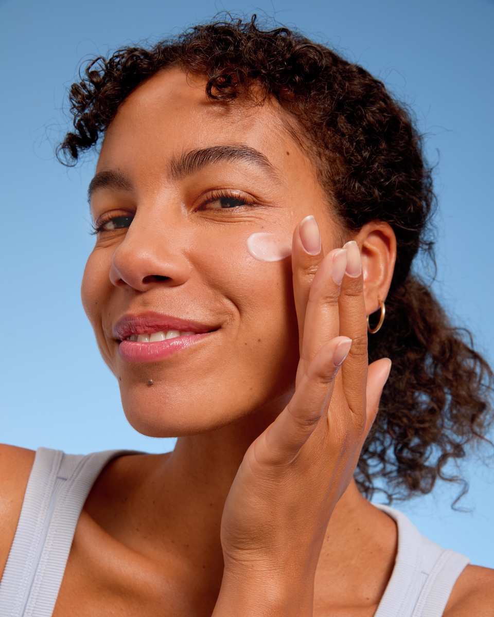 Joven aplicándose crema facial