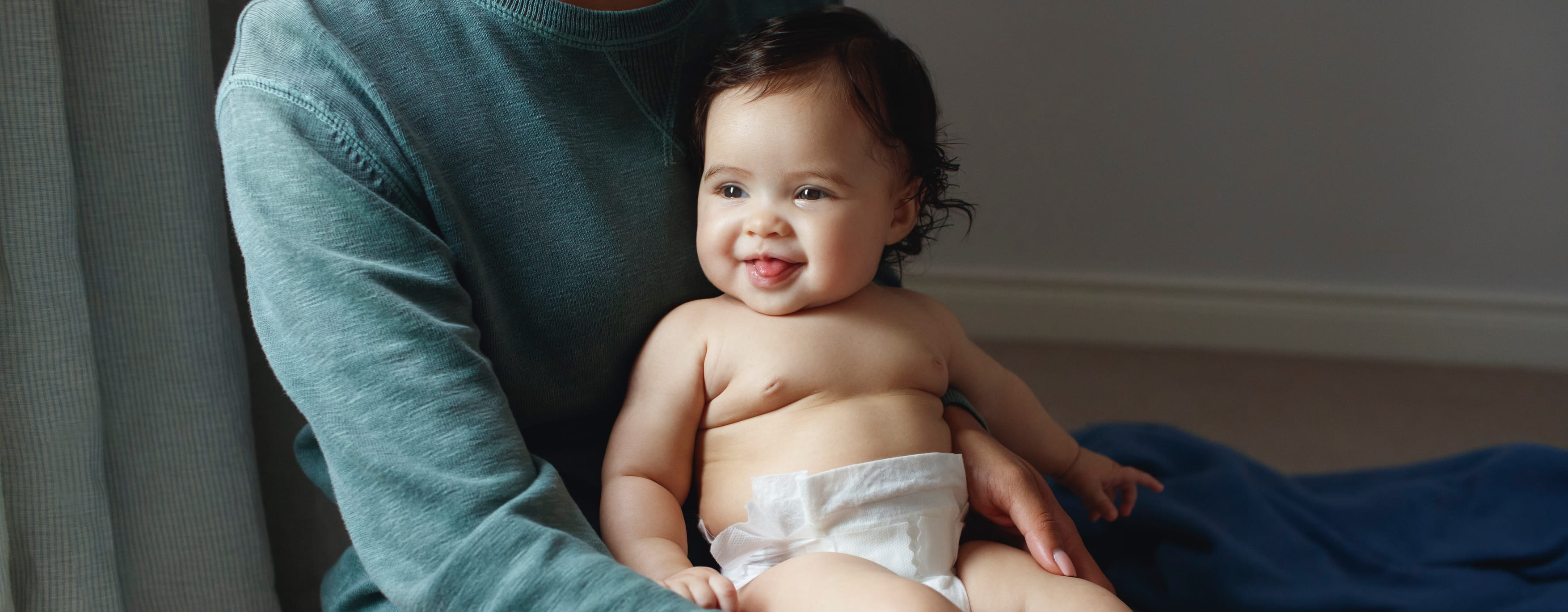 Baby sitzt auf dem Schoß seiner Mutter
