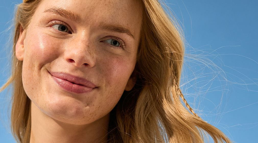 Femme blonde aux yeux bleu sur fond blue