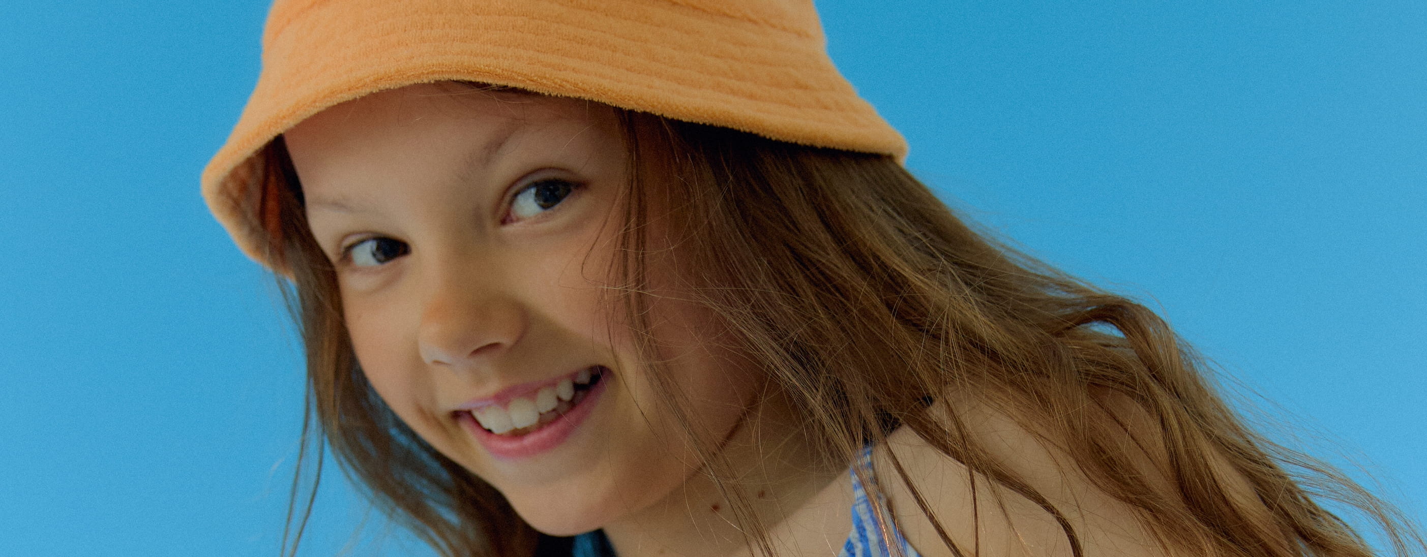 egy kislány, aki NIVEA Kids Protect & Care Suncream SPF 50+ krémet használ