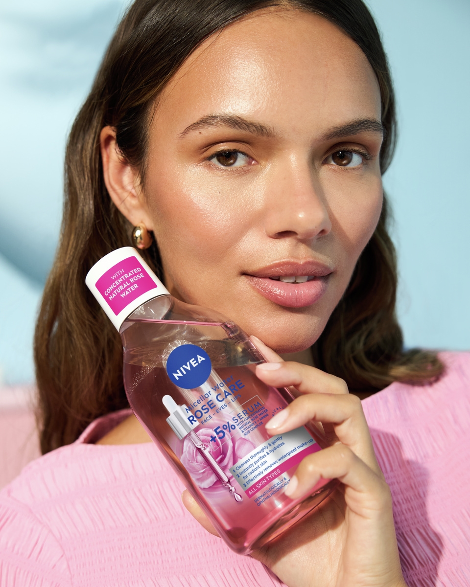 Jonge vrouw die Nivea Micellair Water Rozenverzorging gebruikt