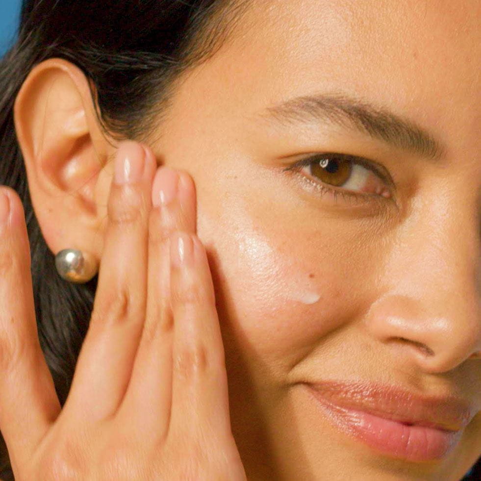 Woman cleansing and exfoliating skin