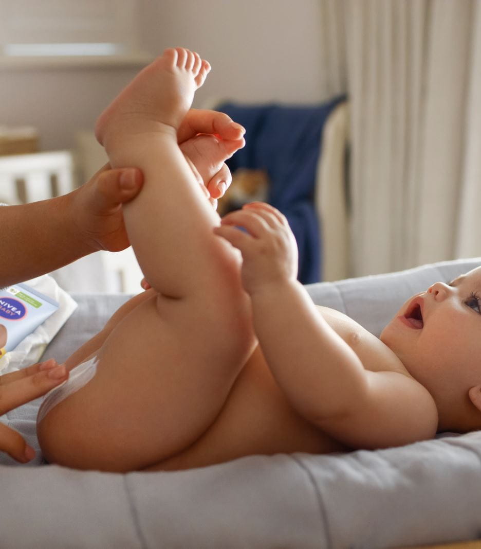 Eine Mutter, die Nivea-Creme gegen Windelausschlag aufträgt