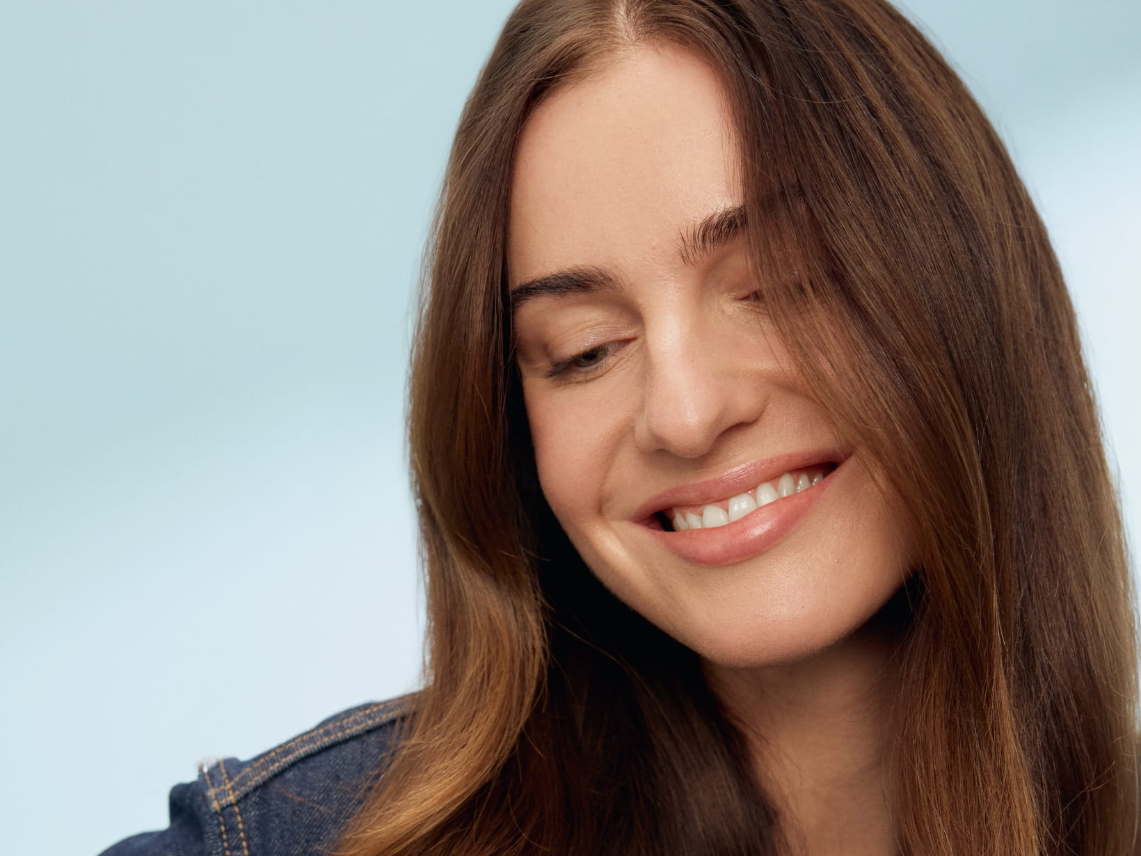 En person som ler och tittar ner år vänster