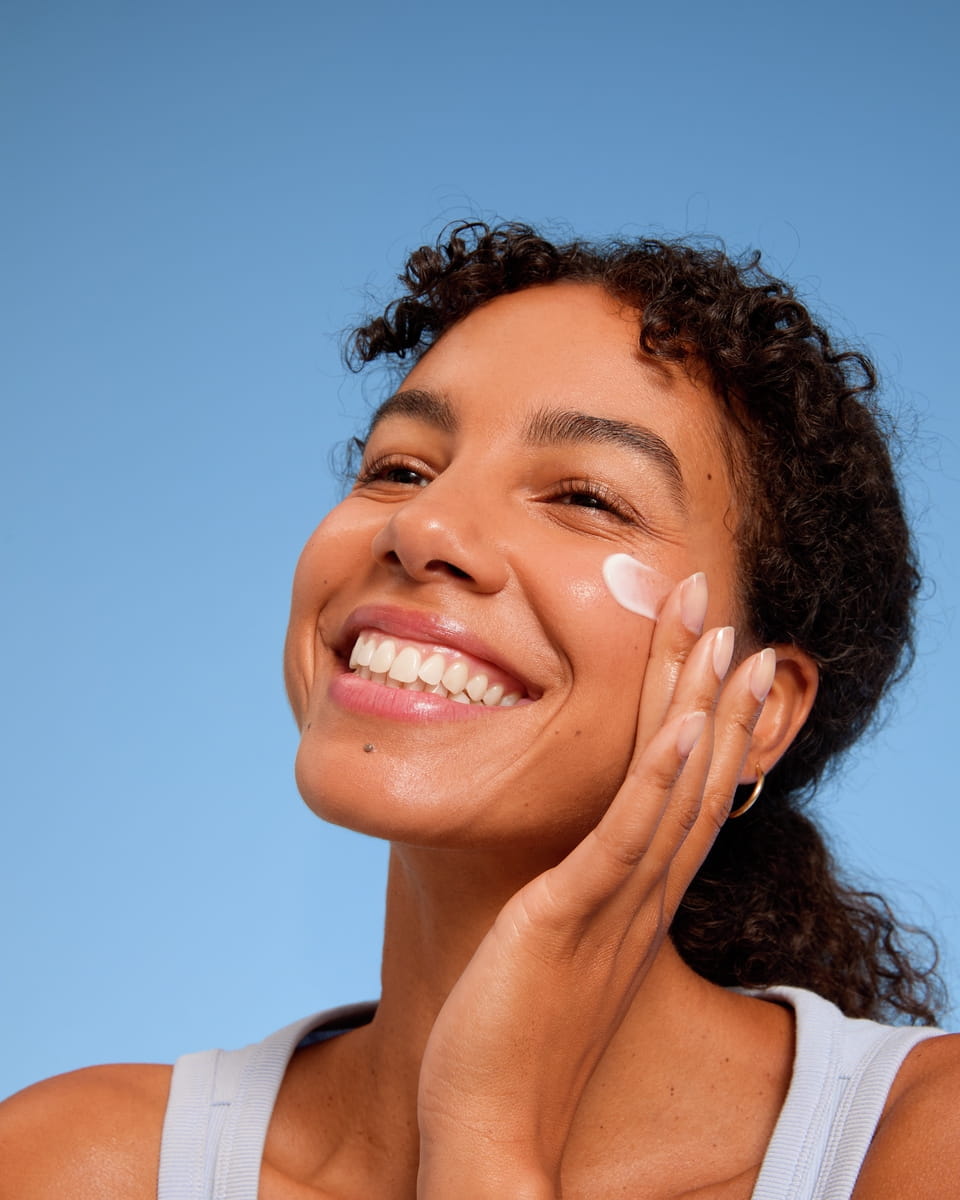 Jeune femme appliquant la crème pour le visage Nivea