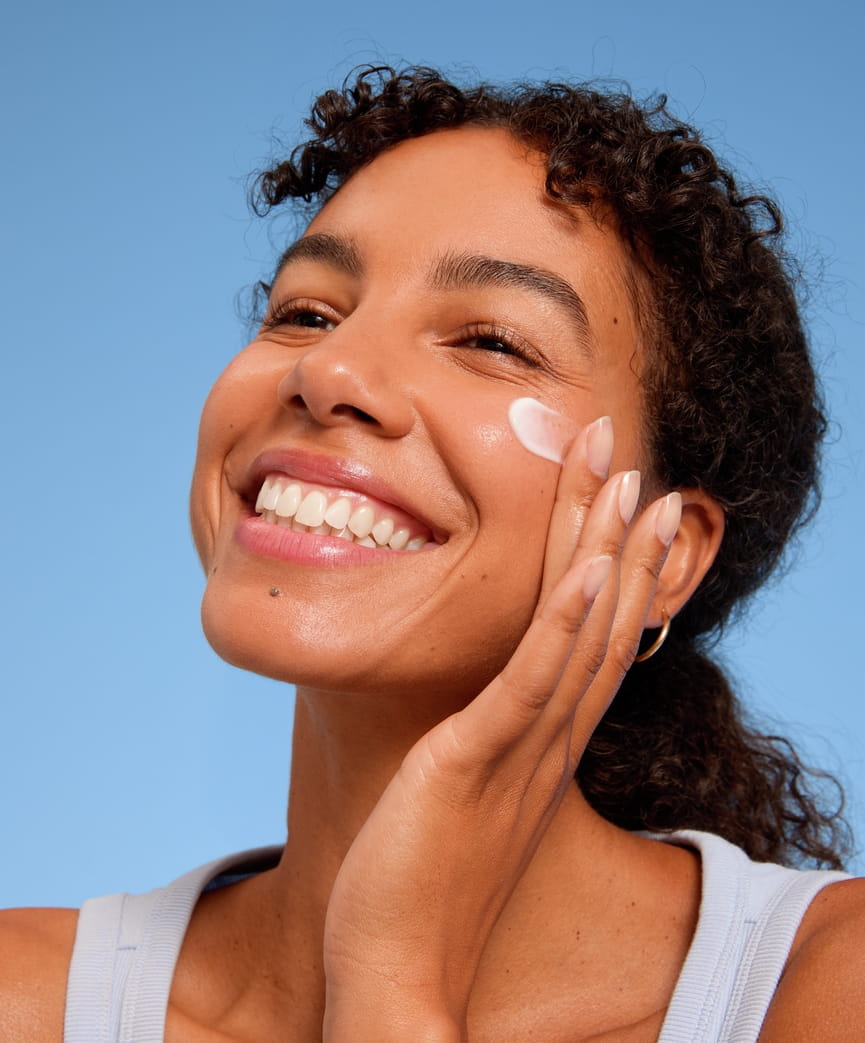 Jeune femme appliquant la crème pour le visage Nivea