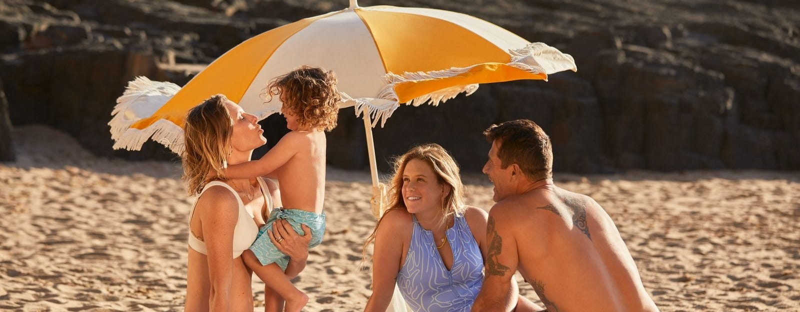 Familie am Strand unterm Sonnenschirm