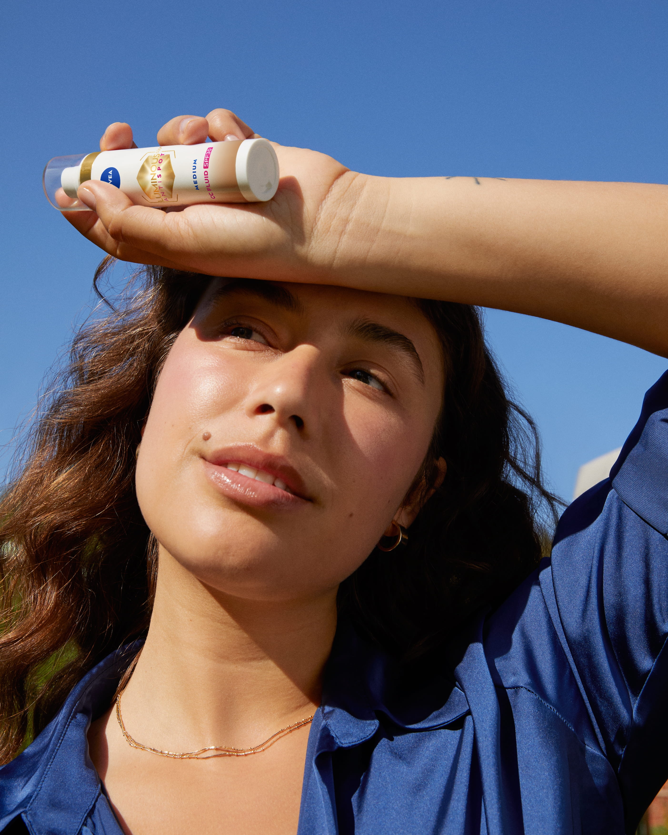 ung kvinna som använder Nivea Luminous tinted ansiktskräm