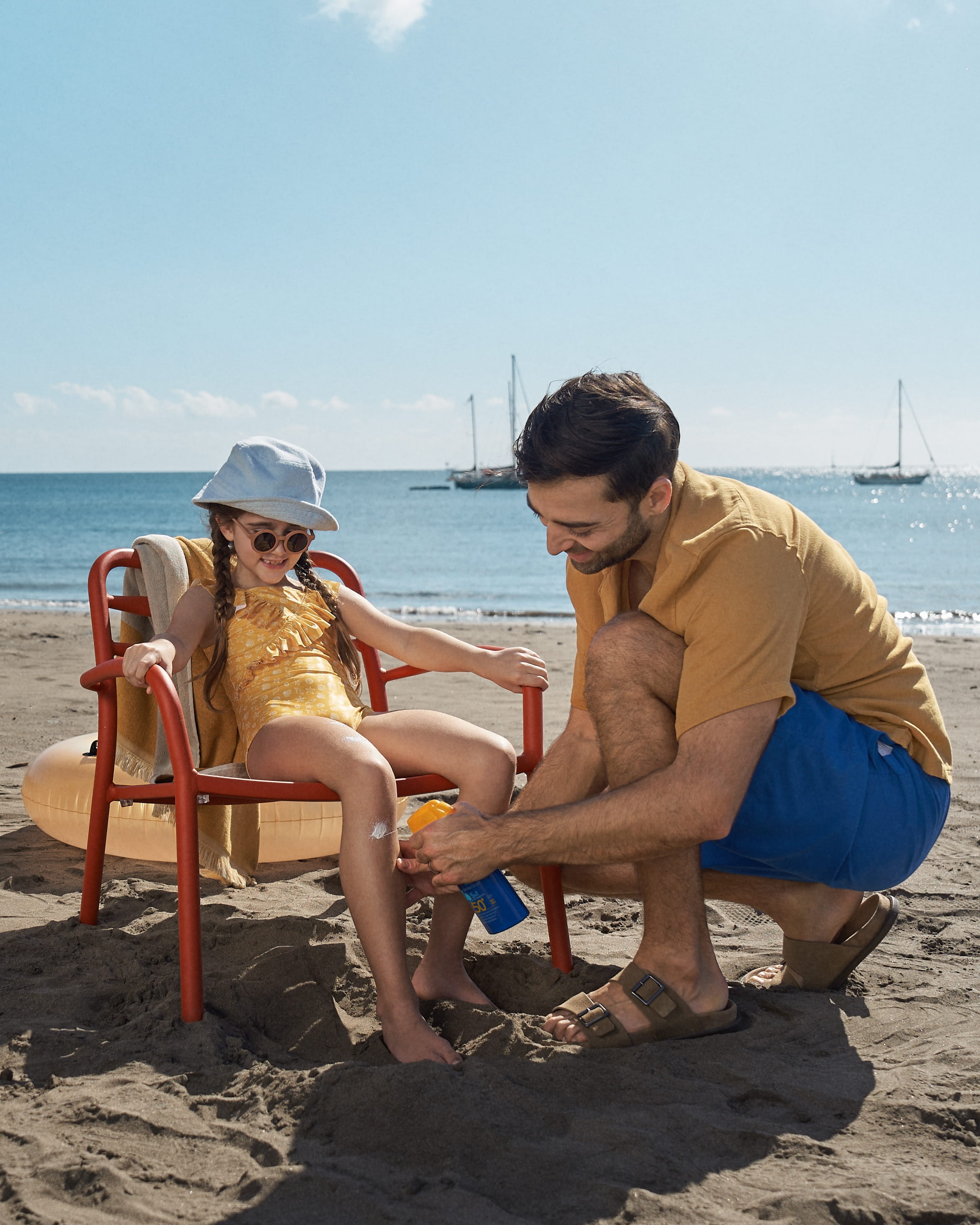 Baby and child on beach with hotspots marking sunscreen application zones